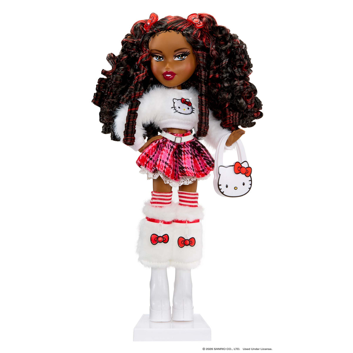 A fashion doll with dark curly hair styled in red and black plaid, wearing a white and red Hello Kitty outfit with a matching handbag, standing on a white display base against a white background.