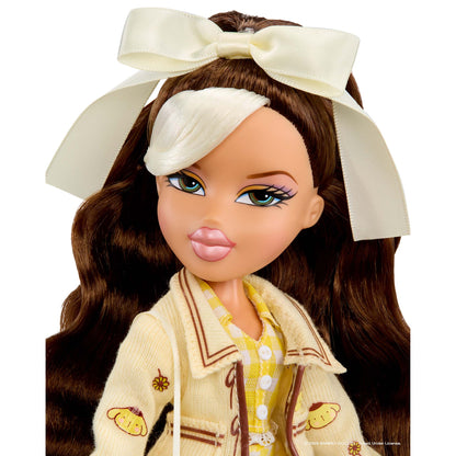 A close-up of a doll with long brown hair, wearing a large cream bow headband, a cream cardigan with brown trim, and a yellow-and-white patterned shirt, shown against a plain white background.