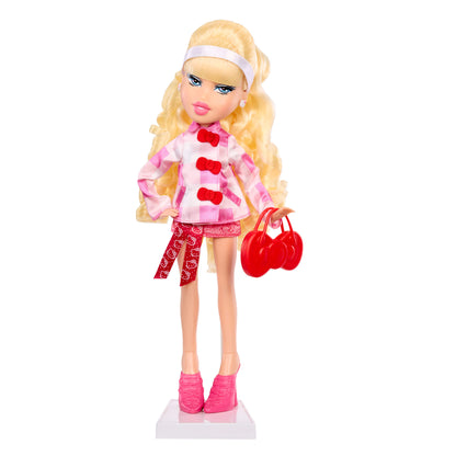 Toy doll with blonde hair, pink outfit, and red shoes on a white background