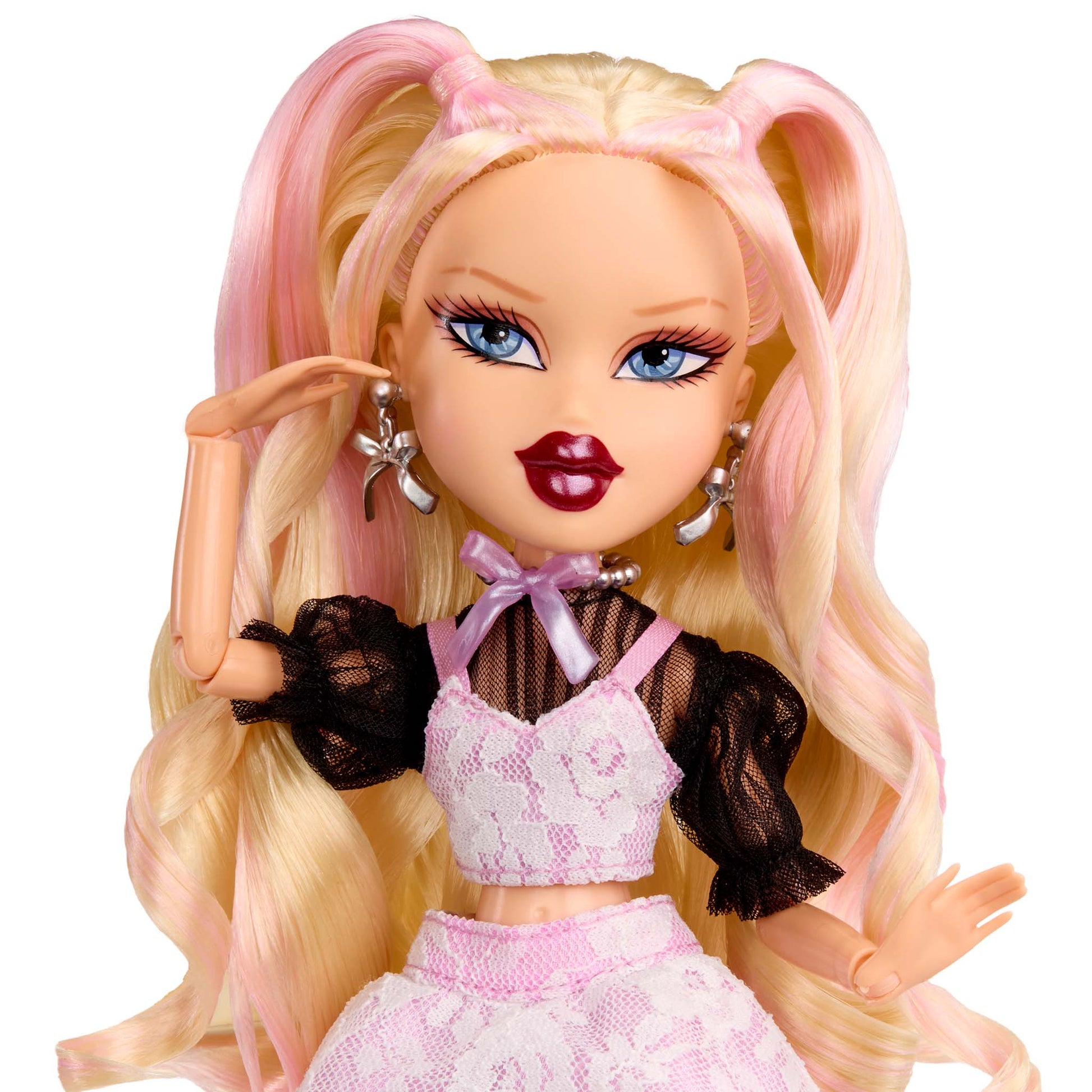 Doll up-close with blonde hair styled in pigtails, wearing a pink outfit 
