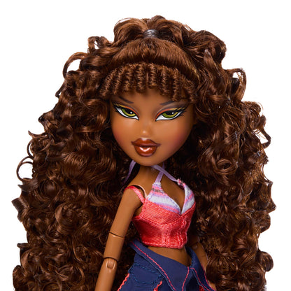 Sasha first reimagined doll close-up of a doll with long, voluminous brown curly hair, green eyes, and brown skin, wearing a pink and blue outfit 