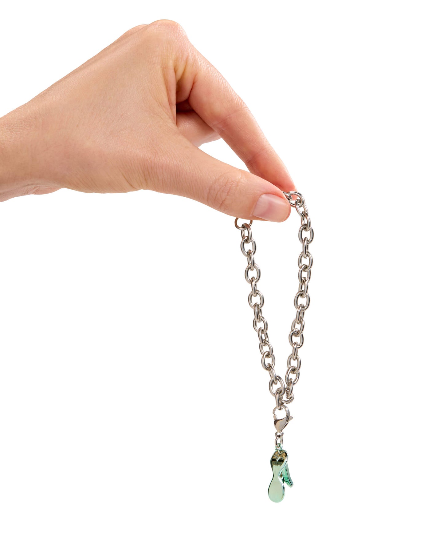 Hand holding a silver chain with a green charm on a white background