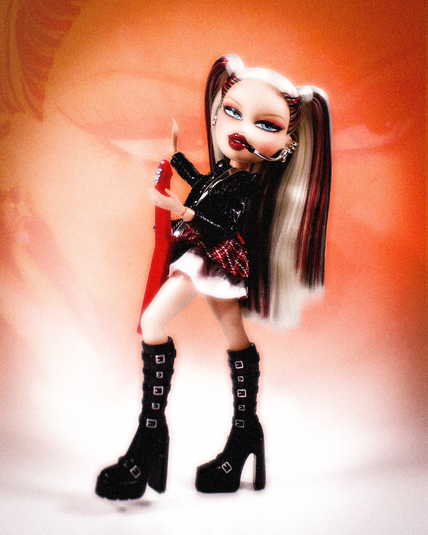Pop Starz Cloe Doll  with black, red and blonde hair, blue eyes, and black outfit on a blurred background
